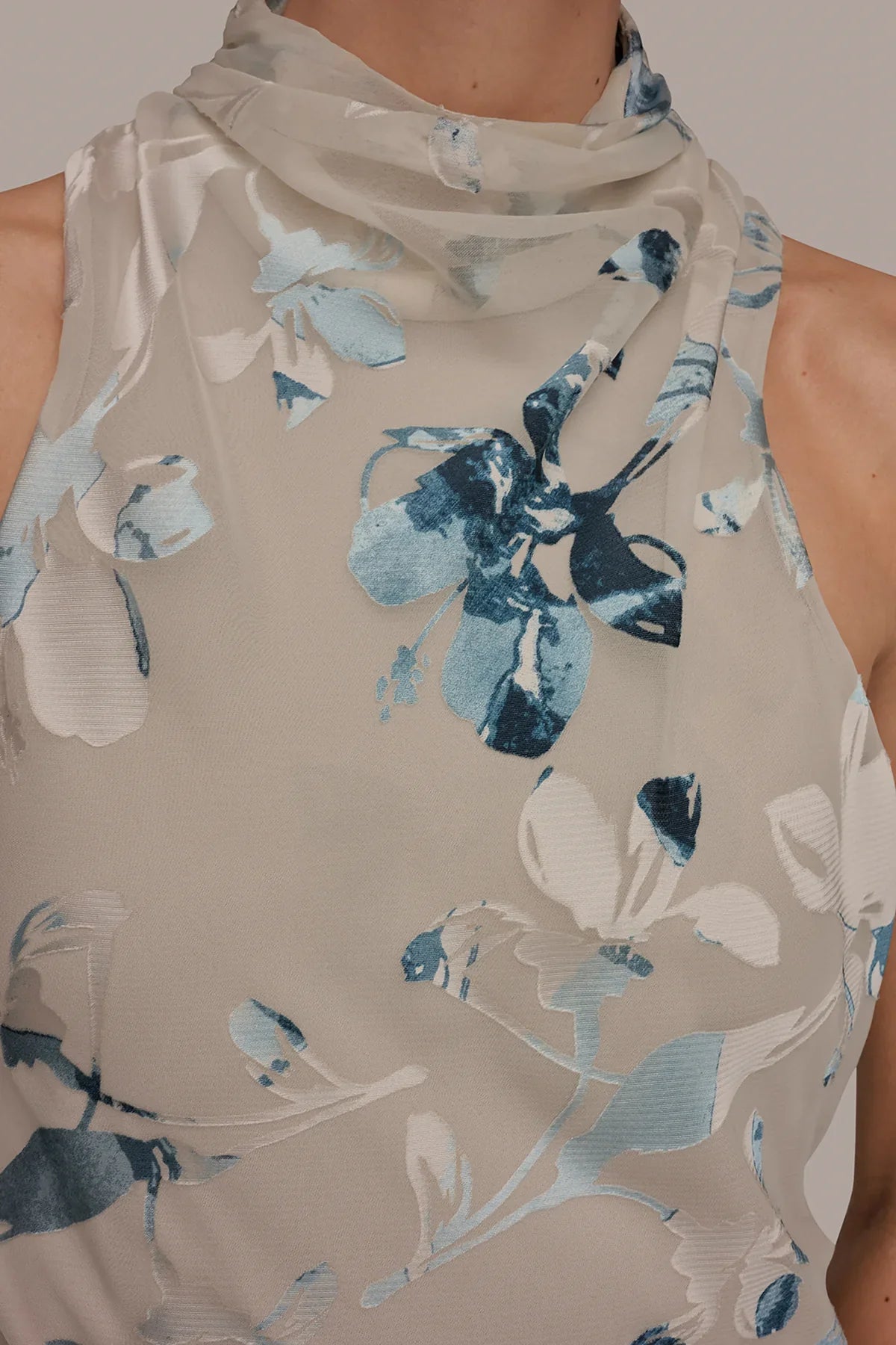 Sleeveless Sea Mist multi midi dress fabric close-up with blue floral burnout and high neck.