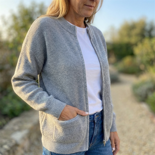 Gray knit zip-up cardigan with ribbed texture and front patch pockets