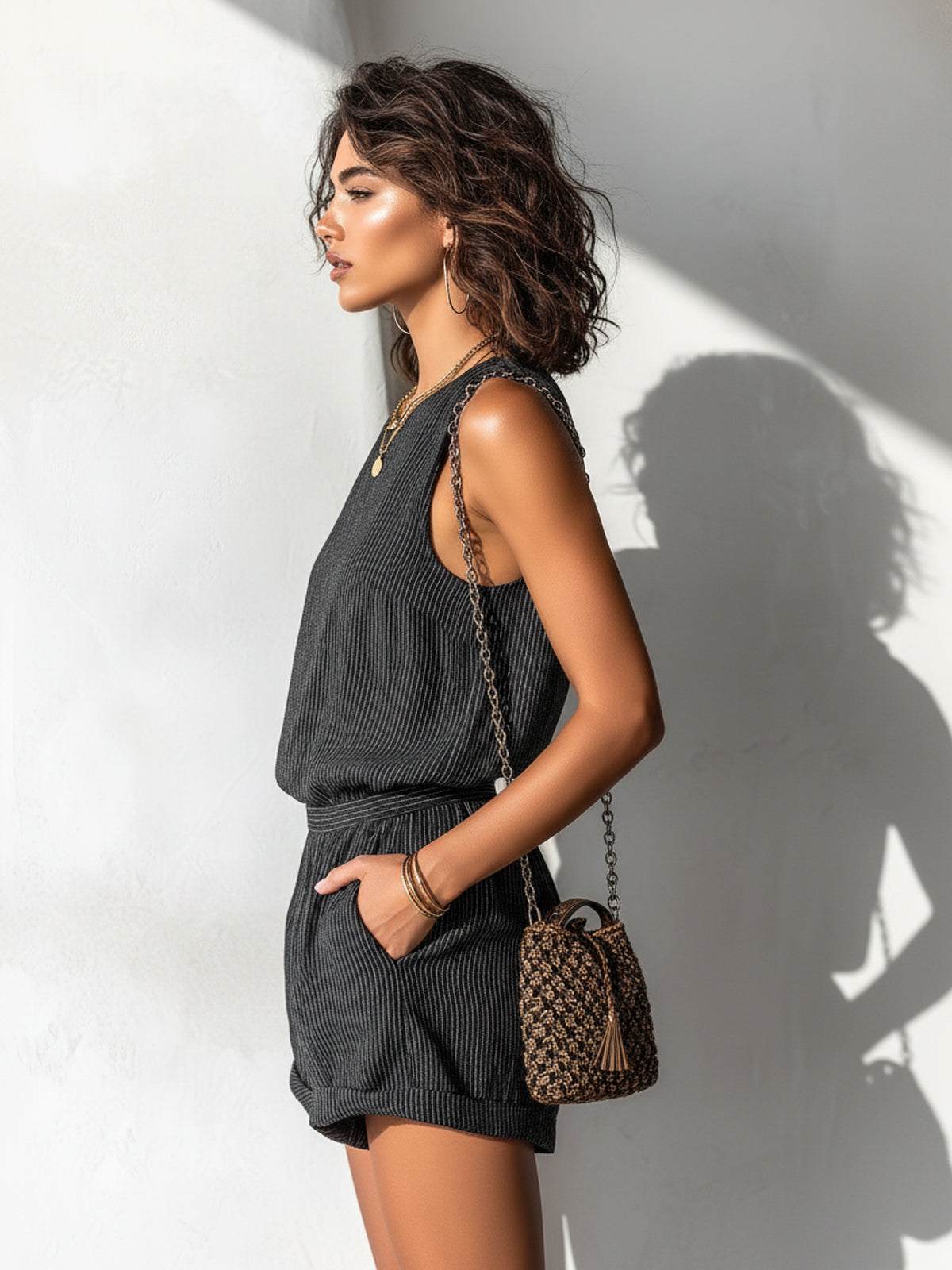 Black striped sleeveless romper, side view, tailored waist and short legs