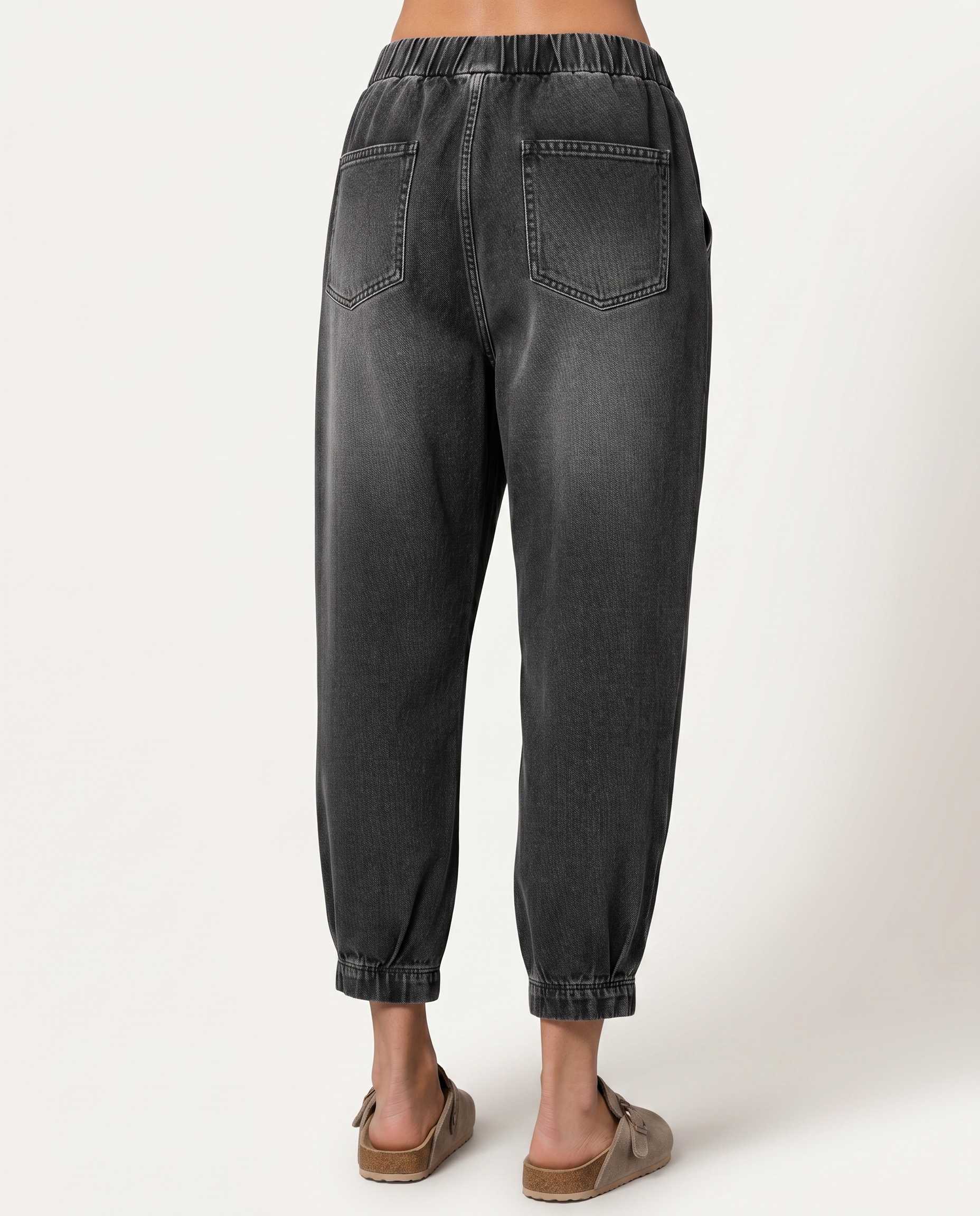 Black tapered denim jeans with back patch pockets and cuffed elastic hems