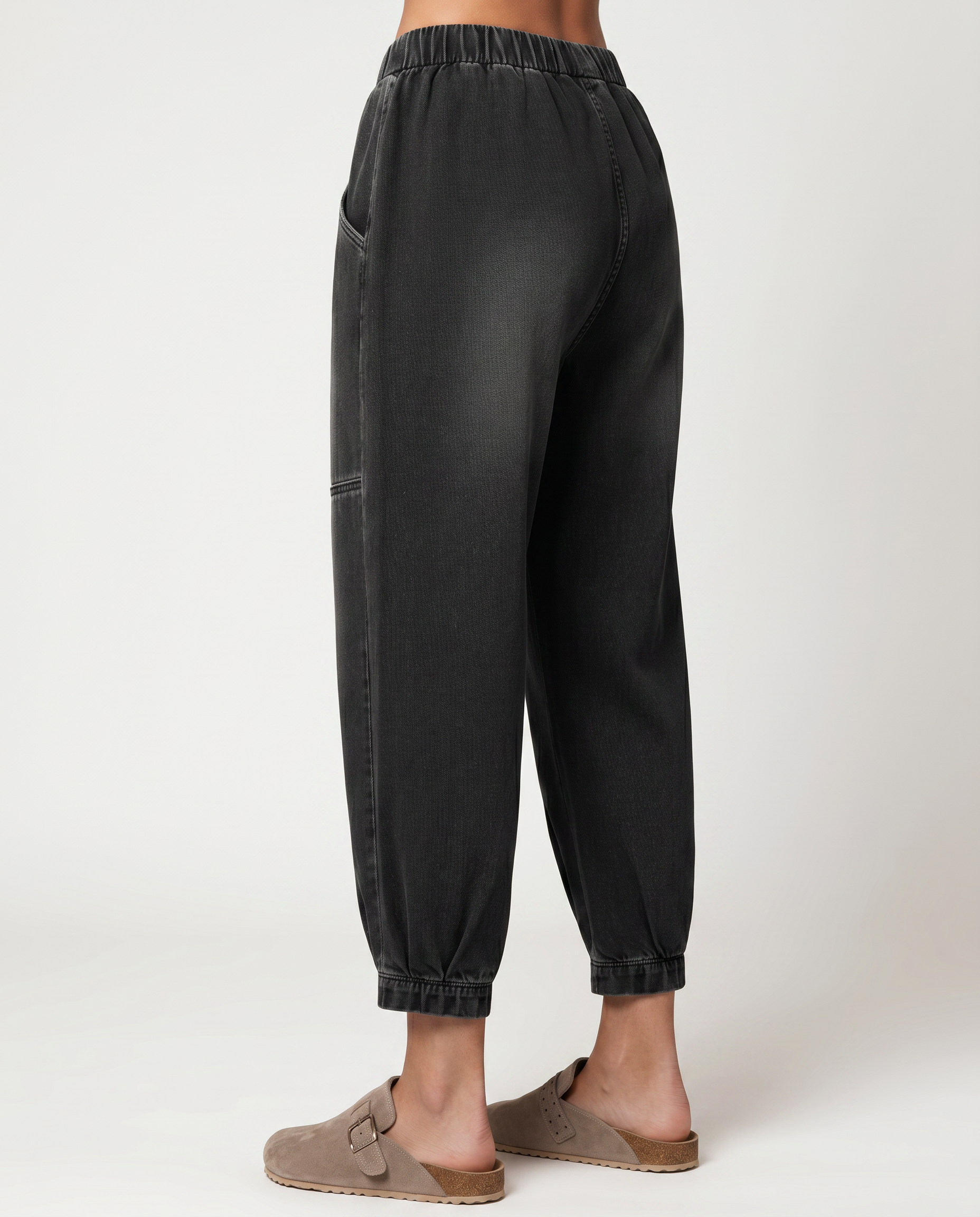 Black tapered denim jeans with elastic waist, side seams, and cuffed hems