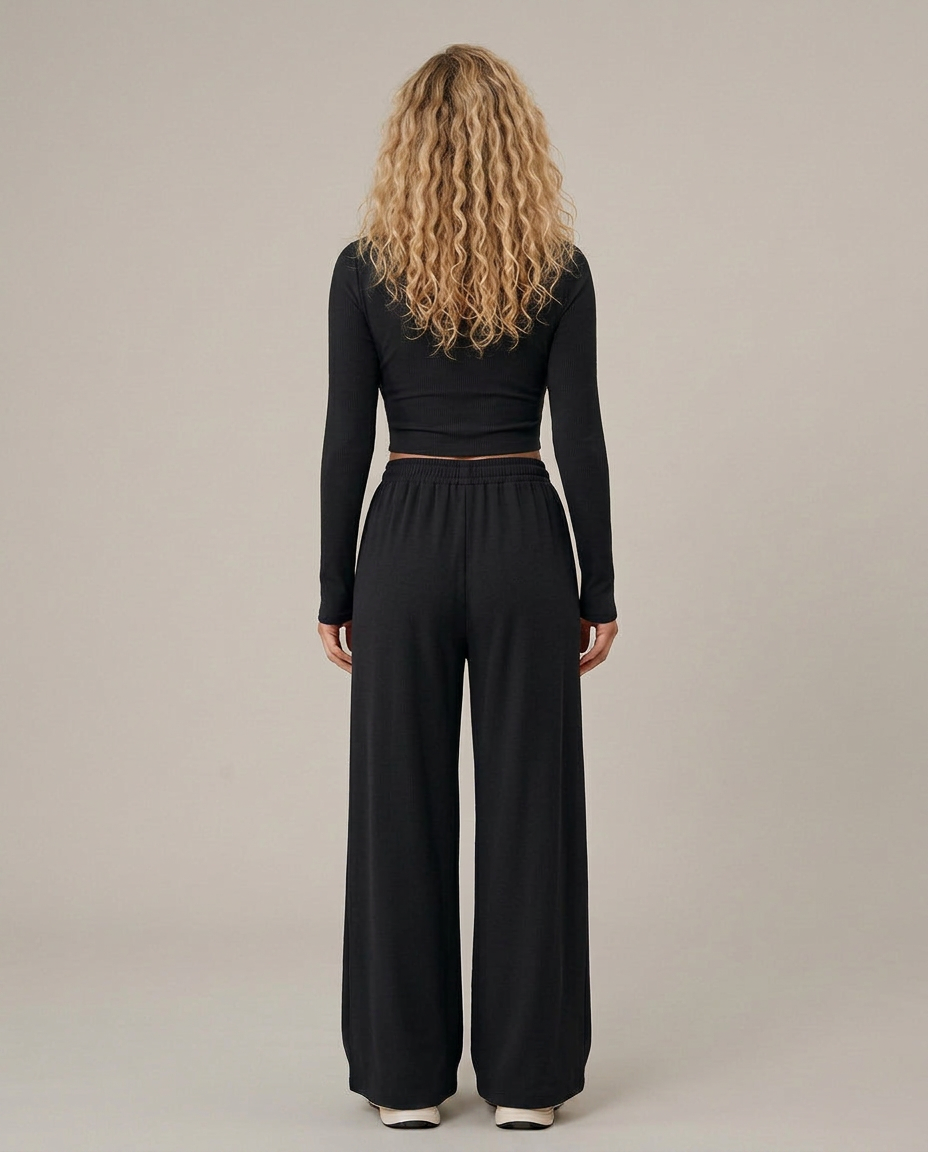 Two-piece set with black long-sleeve top and wide-leg trousers, back view.