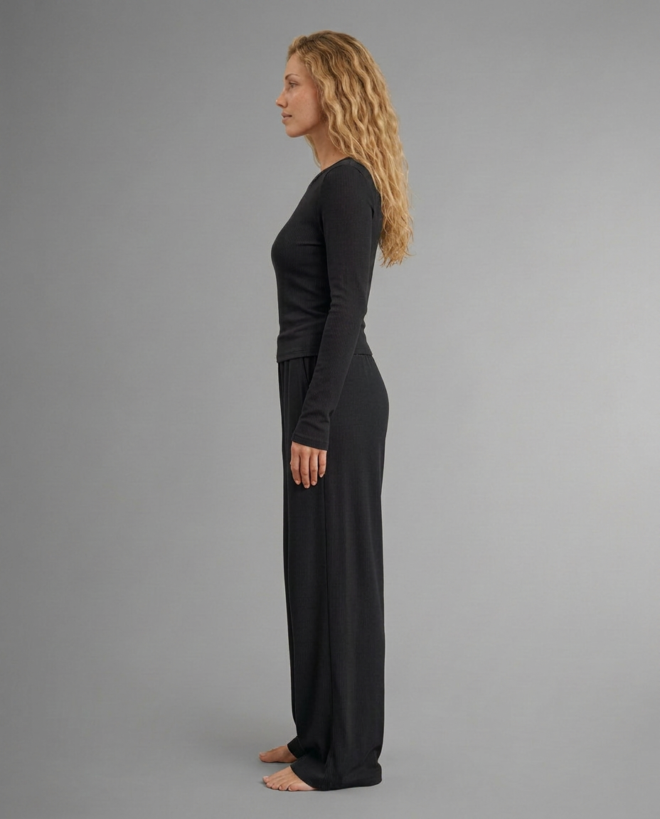 Two-piece set with black long-sleeve top and wide-leg trousers, side profile view.