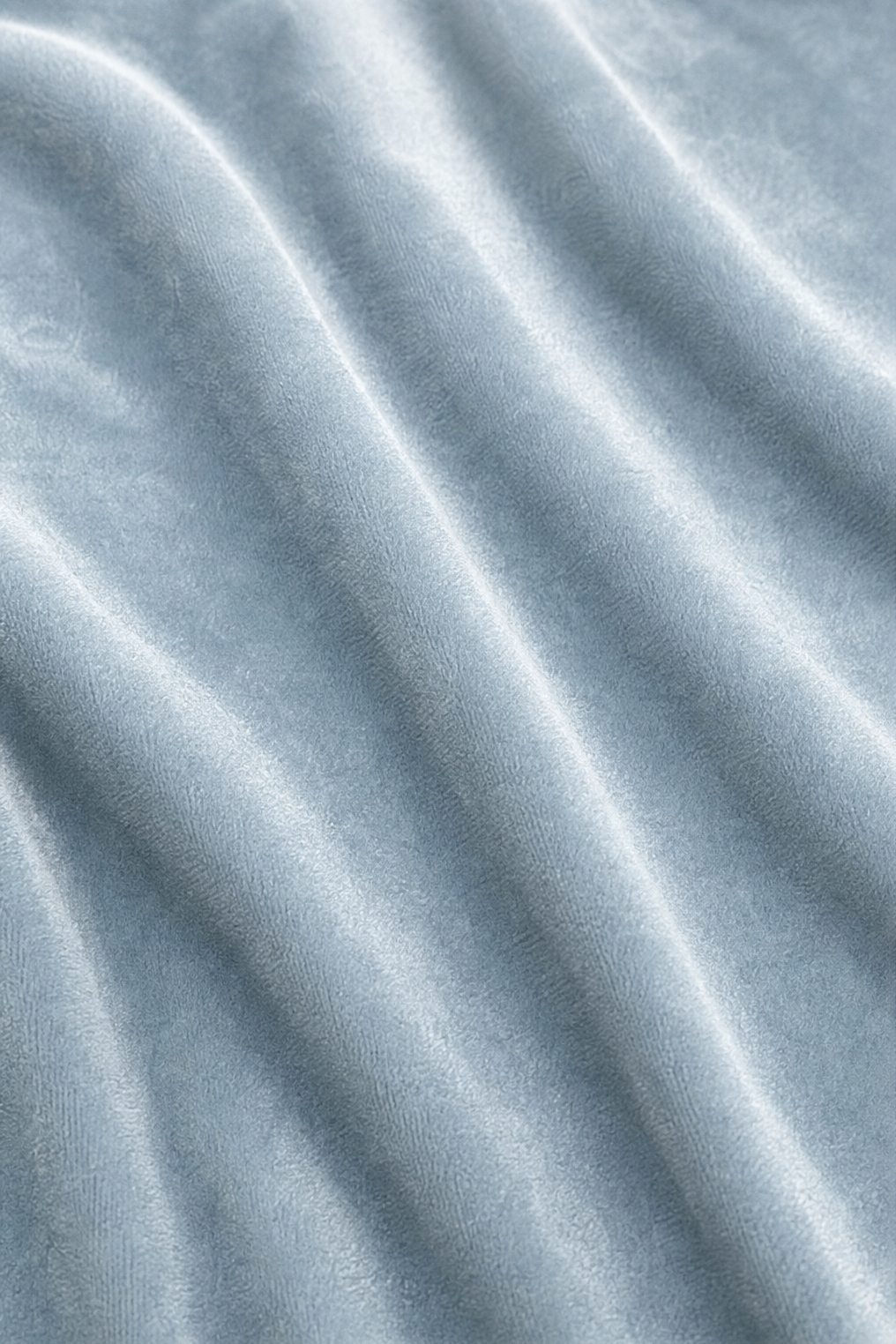 Close-up of the soft pile texture on light blue velvet blouse fabric