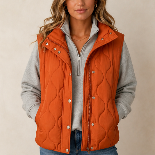 Orange wavy quilted cropped vest with stand collar, zipper, and snap buttons