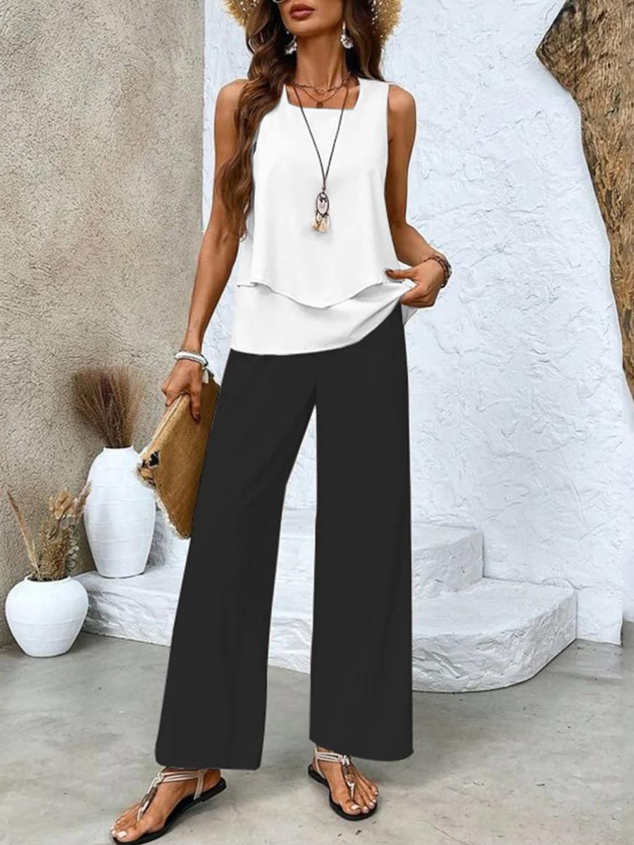 White sleeveless two-piece set with layered top and black wide-leg pants