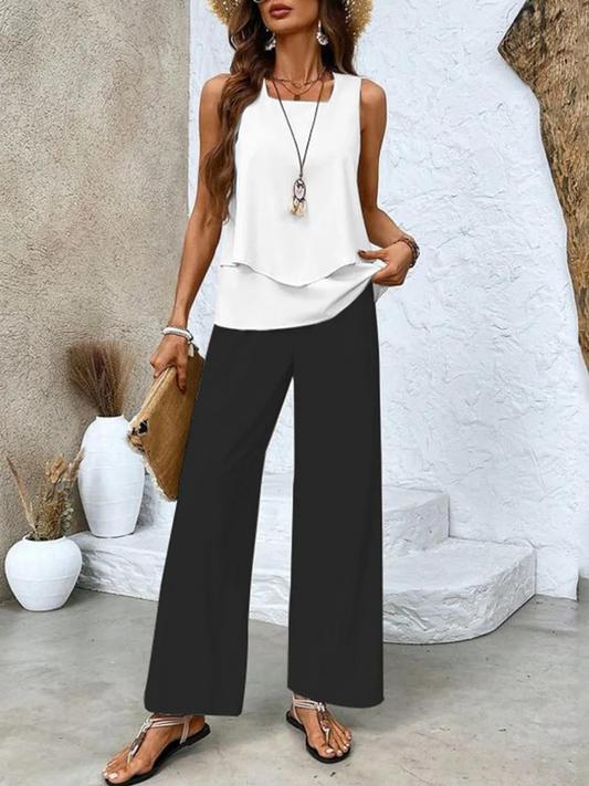 White sleeveless two-piece set with layered top and black wide-leg pants