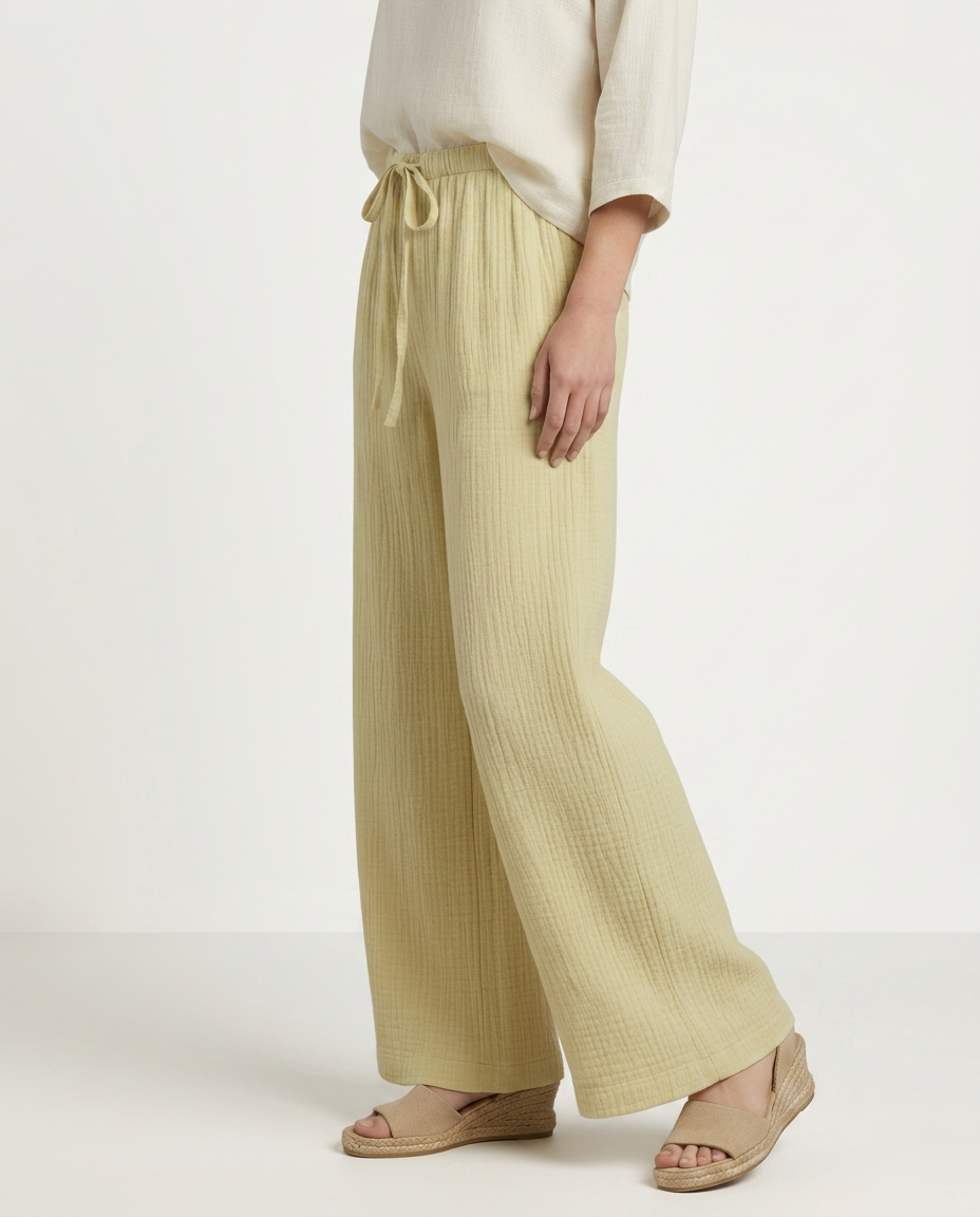 Light yellow wide-leg trousers with elastic waist and drawstring, full-length flowy fit