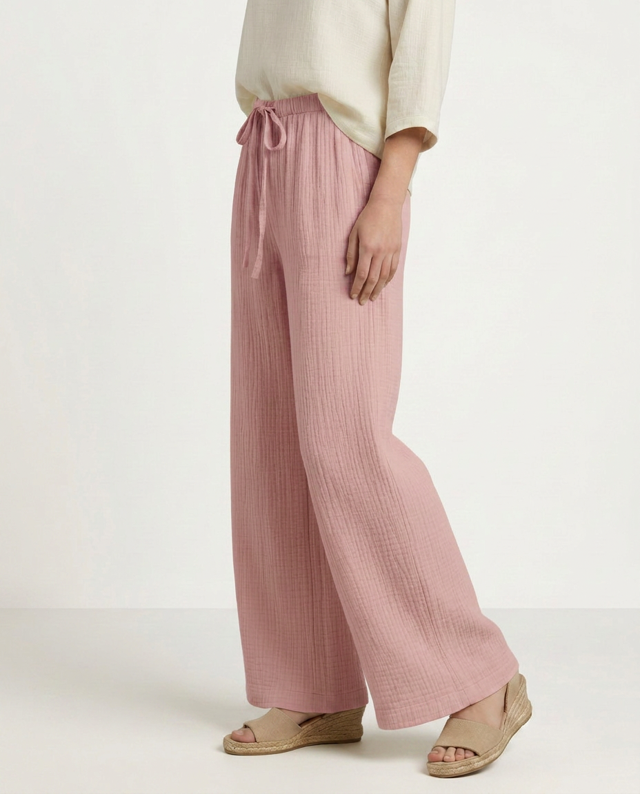 Soft pink wide-leg trousers with elastic waist and drawstring, full length side view