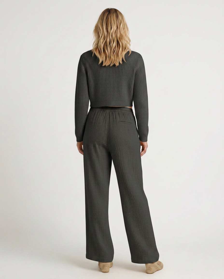 Wide-leg trousers with elastic waist and drawstring, dark gray striped texture, back view.