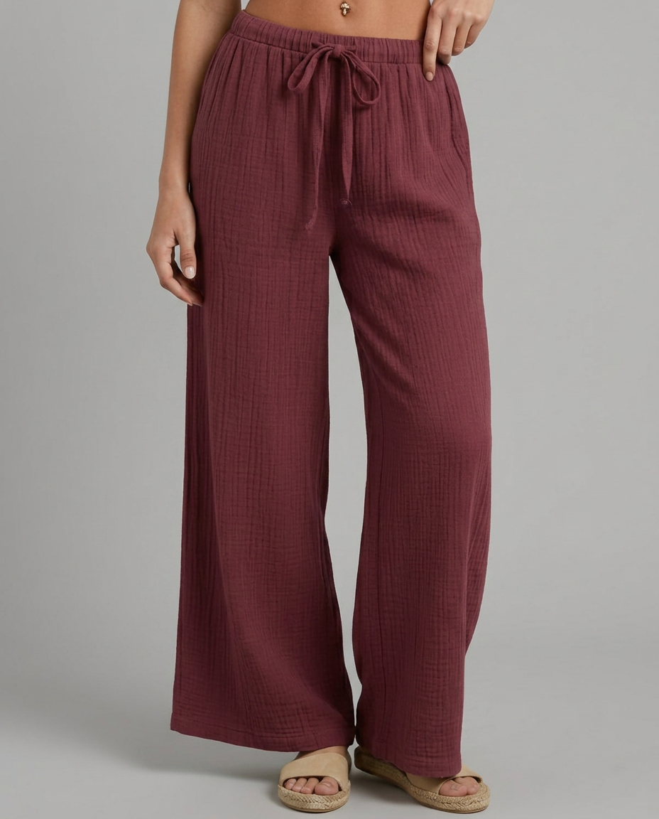 Wide-leg trousers with elastic waist and drawstring, burgundy textured fabric.
