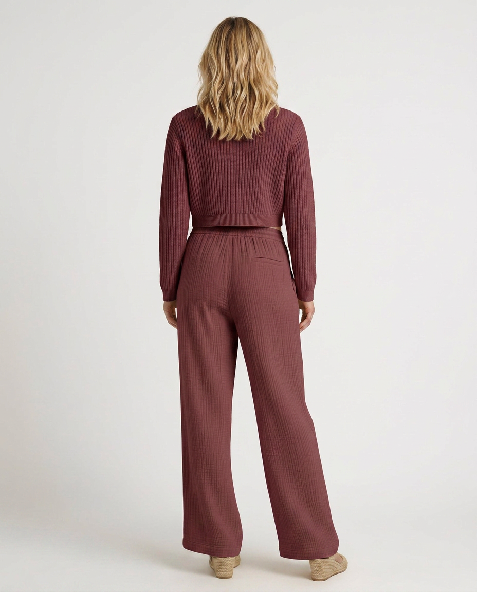 Wide-leg trousers with elastic waist and drawstring, burgundy textured fabric, back view.