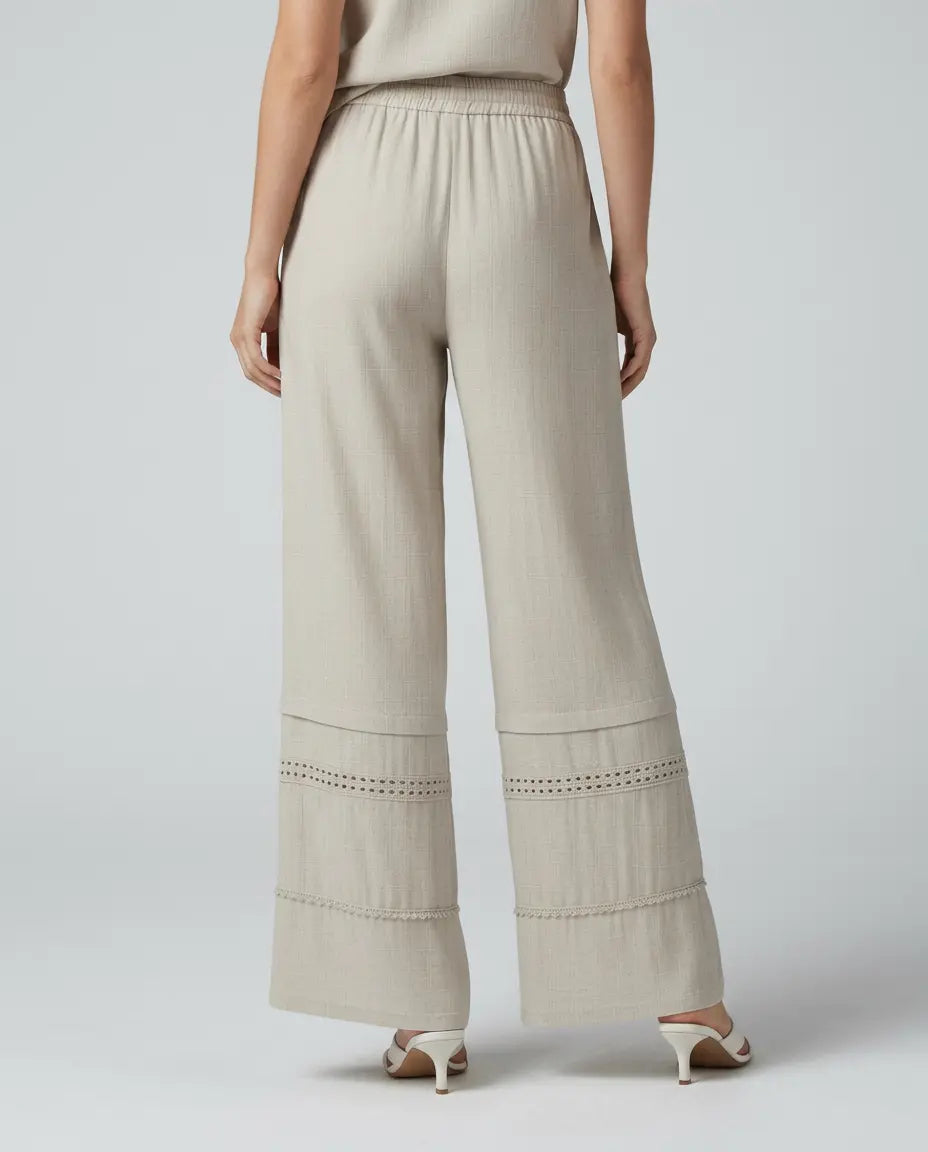 Beige wide leg trousers with lace-trimmed lower panels and elastic waistband
