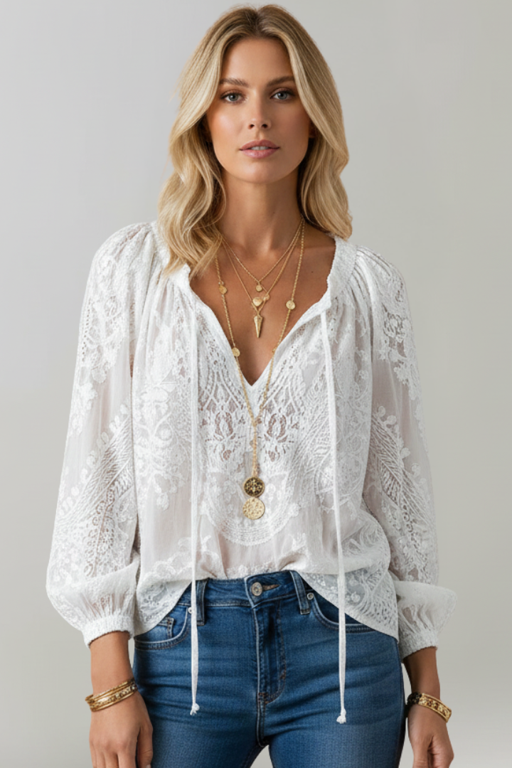 White lace blouse with tied V-neck, long puff sleeves, and embroidered lace overlay